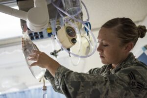 U.S. Air Force Senior Airman Megan Stanton, a medic with the 366th Medical Operations Squadron, hangs a bag of IV fluid for a patient in the urgent care center at Mountain Home Air Force Base, Idaho, July 15, 2013. Stanton's duties included caring for patients and assisting medical providers with treatment. (U.S. Air Force photo by Tech. Sgt. Samuel Morse/Released)