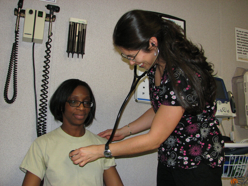 Nurse listening to patient's heart