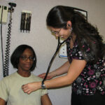Nurse listening to patient's heart
