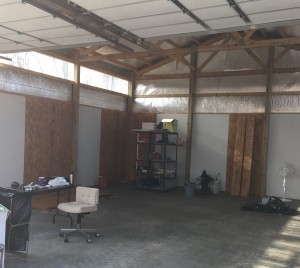 Inside of the shed with wall panels in place. Some are painted and some aren't.