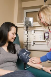 Nurse checking a patient's blood pressure.